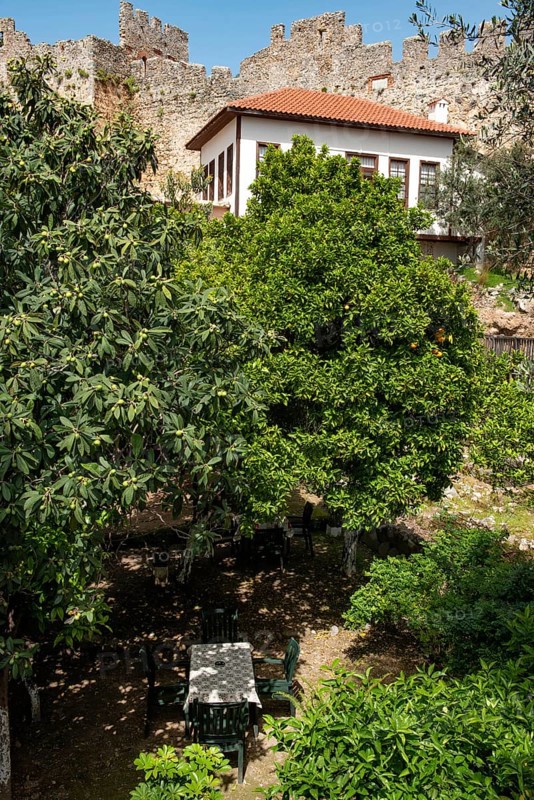 Alanya, Turkey. April 7th 2021 An empty table in a garden cafe inside the old castle walls of Alanya Red Tower, near the Mediterranean harbour, Turkey