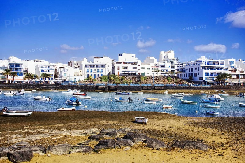 Numerous boats in the Charco de San Ginés lagoon, surrounded by white buildings on the shore, Arrecife, Lanzarote, Canary Islands, Spain