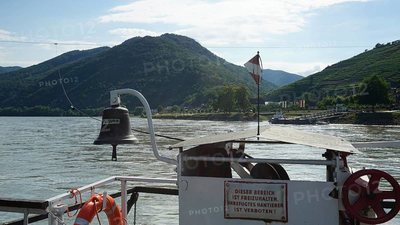 Ferry view of the Danube with flag and green mountains, long-distance cycle path, Danube cycle path, Austria