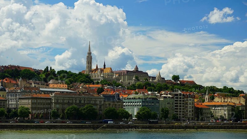City view of the old town of Budapest, Historic buildings on a hill overlooking the Danube under a cloudy blue sky, Budapest