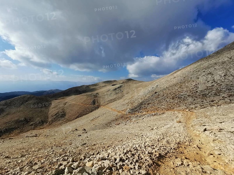 Open mountain trail on Tahtali Dagi under a partly cloudy sky with a wide view, climbing Tahtali Dagi, Lycia, Turkey