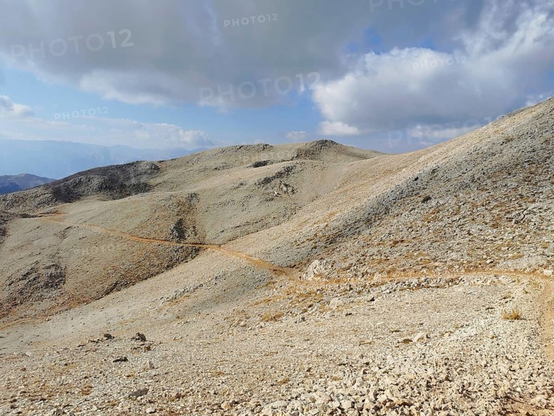 A narrow path snakes through a rocky mountain landscape, climbing Tahtali Dagi, Lycia, Turkey