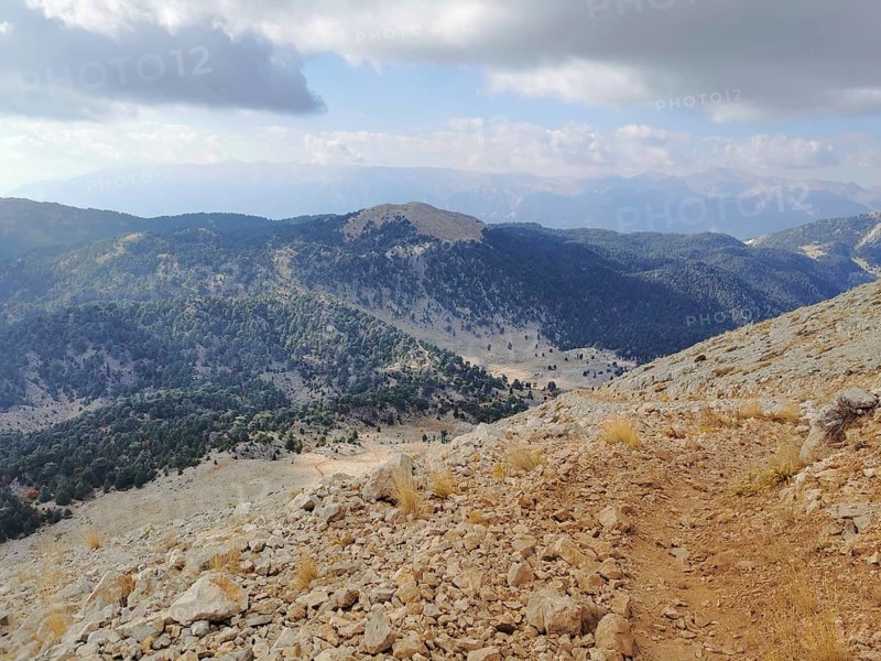 Extensive mountain view with wooded slopes and a rocky trail climb of Tahtali Dagi, Lycia, Turkey