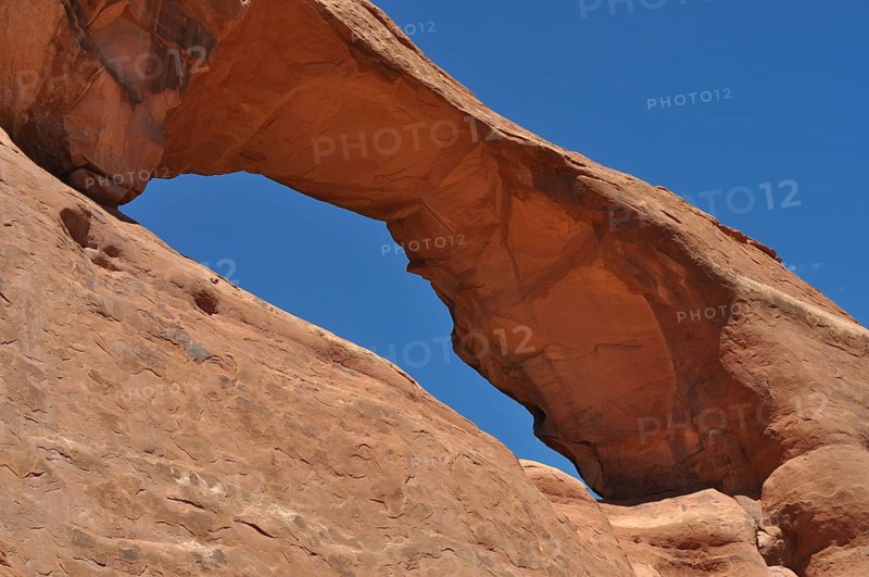 Skyline Arch, a massive sandstone arch in the desert under clear skies, Arches National Park, Utah, USA