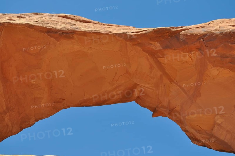 Skyline Arch, a sand-colored rock arch standing out against the blue sky, Arches National Park, Utah, USA