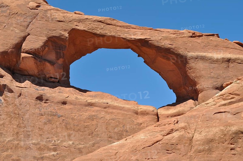 Skyline Arch, a sandstone arch under clear blue sky, Arches National Park, Utah, USA