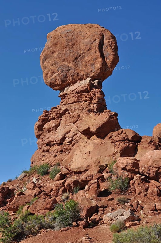 A massive, balanced rock formation in the midst of a barren desert landscape, Arches National Park, Utah, USA
