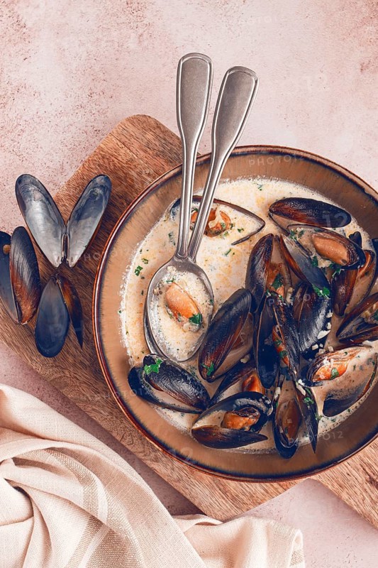 Mussels in creamy garlic sauce, served with fresh herbs and spices, homemade, no people