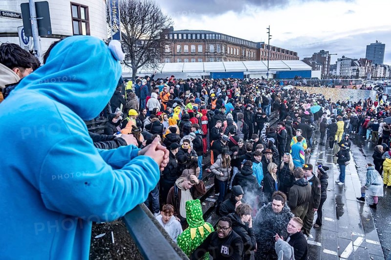 Banks of the Rhine on the old town, despite rainy weather, many, mostly young people gather here to celebrate on Rose Monday in Düsseldorf, North Rhine-Westphalia, Germany