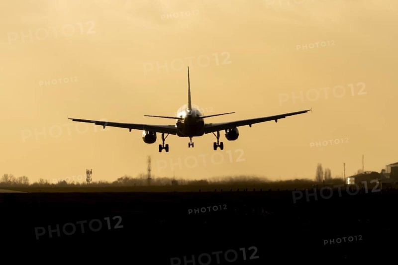 Airbus A320 commercial passenger airliner jet aircraft of Electra airlines flying on approach to land at sunset at London Stansted airport, Essex, England, United Kingdom