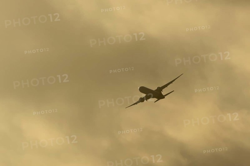Commercial passenger airliner jet aircraft in flight at sunset at London Stansted airport, Essex, England, United Kingdom