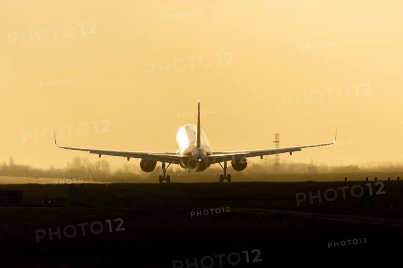 Boeing 777 commercial passenger airliner jet aircraft landing on a runway at sunset at London Stansted airport, Essex, England, United Kingdom