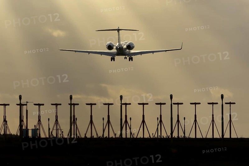 Executive business jet aircraft in flight on approach to land at sunset at London Stansted airport, Essex, England, United Kingdom
