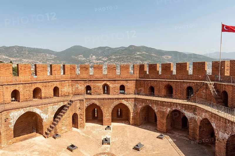 Alanya, Turkey. April 7th 2021 The imposing battlements of the Seljuk era Red Tower or Kizi Kule overlooking Alanya harbour with the Taurus Mountains in the background