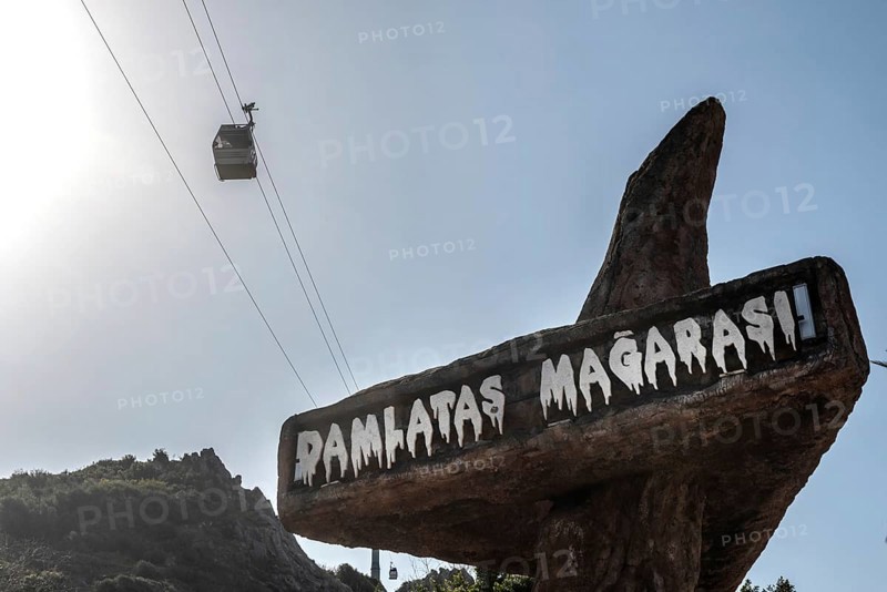 Alanya, Turkey. April 7th 2021 Entrance to Damlatas Magarasi with a cable car passing by. The cave and Teleferic are tourist attractions in the Turkish seaside resort of Alanya, Turkey