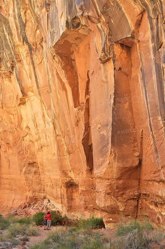 Impressive rock cliff with people below, showing the massive size and natural beauty, Capitol Reef National Park, Utha, USA