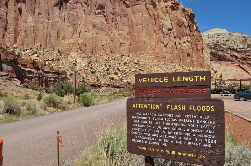 Information sign about possible flash flood hazards in a rocky canyon under clear skies, Capitol Reef National Park, Utha, USA