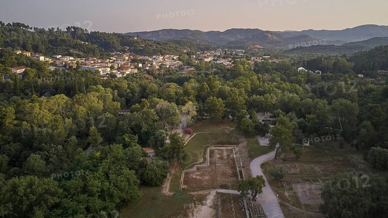 Soft morning light, village, ancient gymnasium, North-Eastern Propylon, Prytaneion, overview of an urban landscape surrounded by wooded areas and hills at dusk, drone shot, archaeological site, Ancient Olympia, Olympia, Peloponnese, Greece