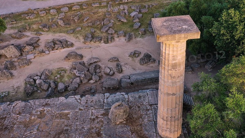 Column of the Temple of Zeus in morning light, close-up of a stone column on a ruined site surrounded by vegetation, drone shot, archaeological site, Ancient Olympia, Olympia, Peloponnese, Greece