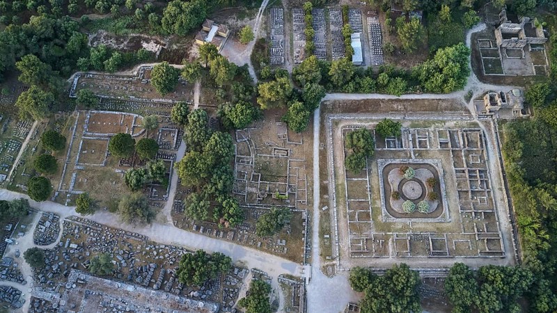 Leonidaion, workshop of Phidias and early Christian Bailica, Heroon, Theocoleon, part of the Temple of Zeus, extensive ruins surrounded by trees and crossed by paths, drone shot, archaeological excavation site, Ancient Olympia, Olympia, Peloponnese, Greece