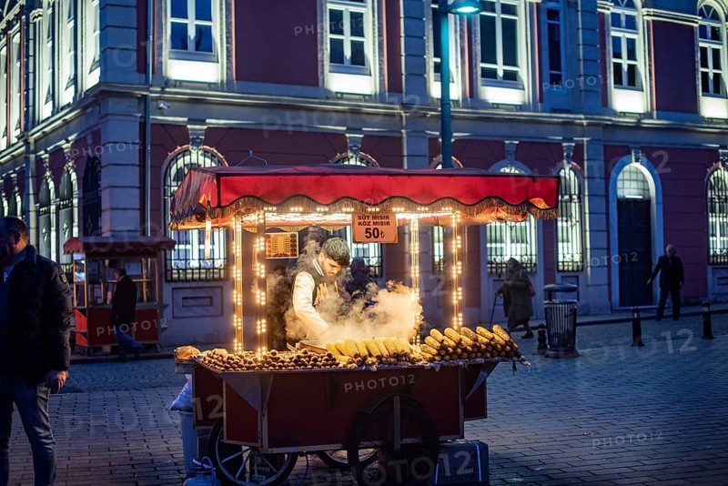 Istanbul, Turkey. January 3rd 2025. A street stall vendor selling sweet corn and roasted chestnuts, traditional street food in Istanbul at night, Turkey
