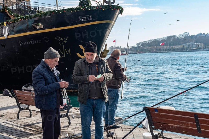 Istanbul, Turkey. January 3rd 2025. Turkish men fishing on the dock at Karakoy Port on the European Shore of the Bosporus Straight, Istanbul, Turkey