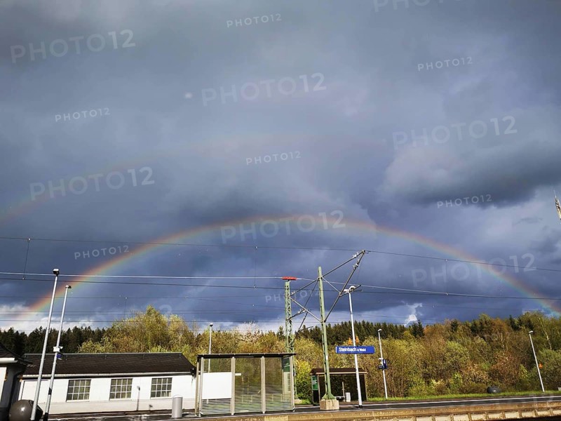Double rainbow over a small train station area under a cloudy sky, Steinbach am Wald, Rennsteig, Frankenwald nature park Park