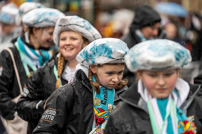 Rose Monday procession in Düsseldorf, parade participants, foot groups, make themselves rainproof, at street carnival, sometimes heavy rain, North Rhine-Westphalia, Germany