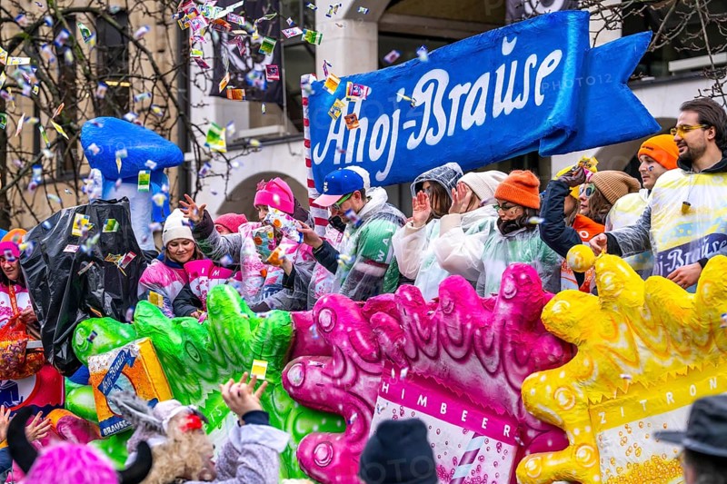 Rose Monday procession in Düsseldorf, theme car from companies, here confectionery manufacturer Ahoj, effervescent, at the street carnival, sometimes in heavy rain, North Rhine-Westphalia, Germany