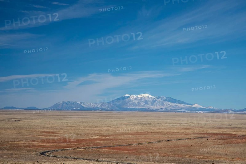 Winslow, Arizona - The San Francisco Peaks, seen from the Meteor Crater, about 45 miles distant. The highest, Humphreys Peak at 12, 637 feet, is the highest place in Arizona. The mountains have religious significance to Native American tribes in the area