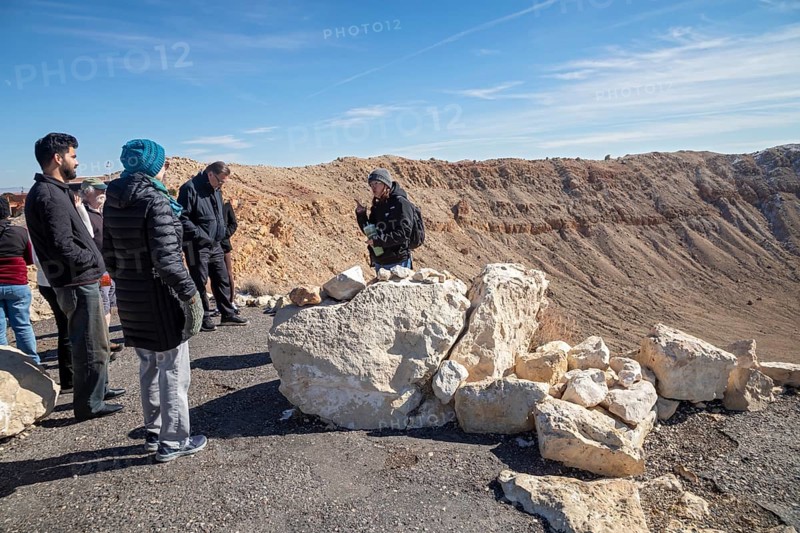 Winslow, Arizona - Meteor Crater. The crater was formed about 50, 000 years ago. It is 560 feet deep and abouat three-quarters of a mile in diameter. It is now a major tourist attraction. A tour guide talks with visitors on the crater's rim