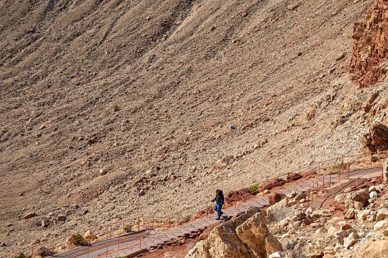 Winslow, Arizona - Meteor Crater. The crater was formed about 50, 000 years ago. It is 560 feet deep and abouat three-quarters of a mile in diameter. It is now a major tourist attraction. A man walks down stairs leading to an observation platform