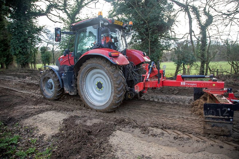 Tractor grading and levelling work repair a muddy, flood-prone country lane, Sutton, Suffolk Sandlings, Suffolk, England, UK