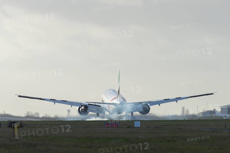 Boeing 777 commercial passenger airliner jet aircraft of Emirates airways landing on the runway at London Stansted airport, Essex, England, United Kingdom