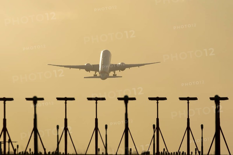 Commercial passenger airliner jet aircraft taking off in flight at sunset at London Stansted airport, Essex, England, United Kingdom