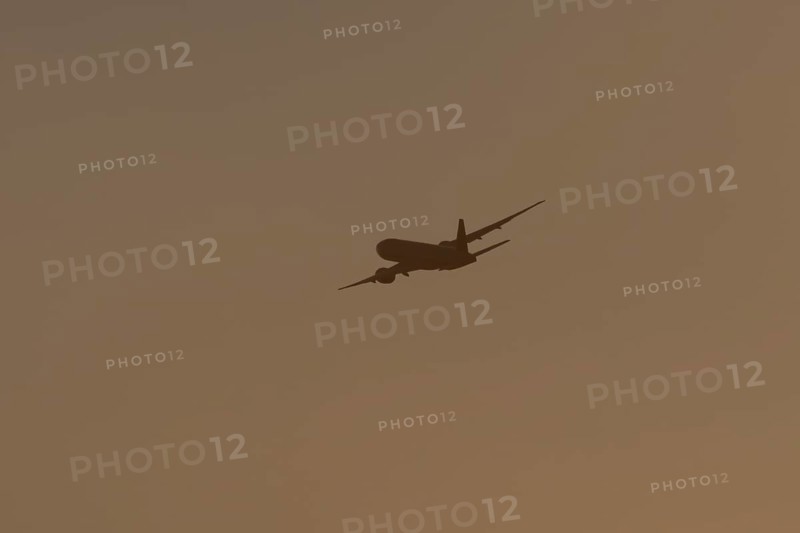 Boeing 777 A7-BFL commercial jet aircraft of Qatar cargo in flight silhouette at sunset at London Stansted airport, Essex, England, United Kingdom