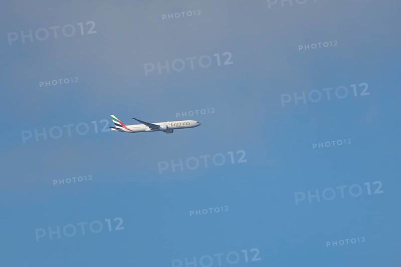 Boeing 777 commercial passenger airliner jet aircraft of Emirates airways in flight at London Stansted airport, Essex, England, United Kingdom