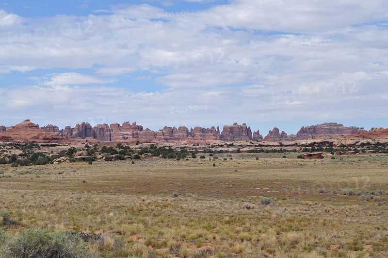 Wide desert landscape with distinctive rock structures under a slightly cloudy sky, Canyonlands National Park, Utah, USA