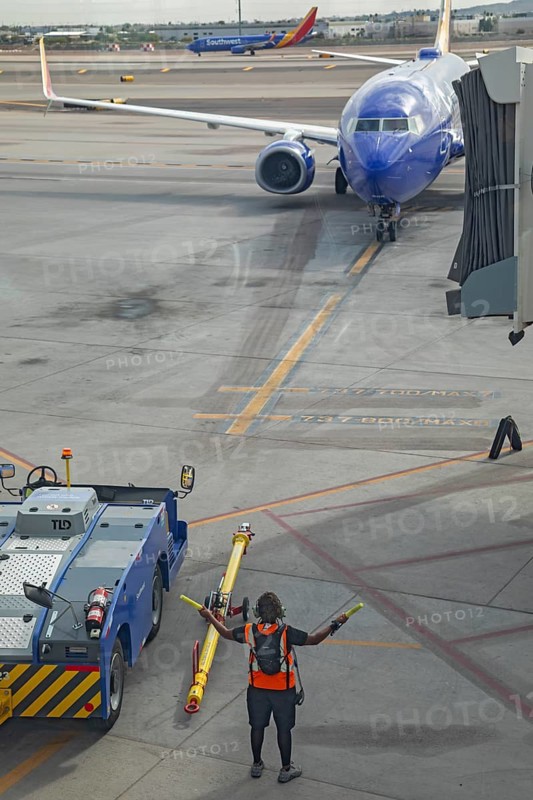 Phoenix, Arizona - A ground crew worker directs a Southwest Airlines jet as it arrives at Sky Harbor International Airport