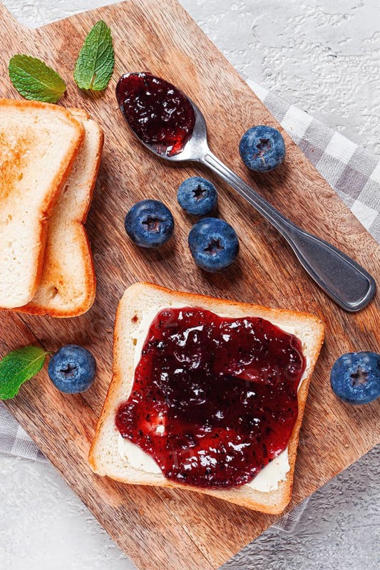 Toast with blueberry jam, on a wooden chopping board, breakfast, homemade, no people