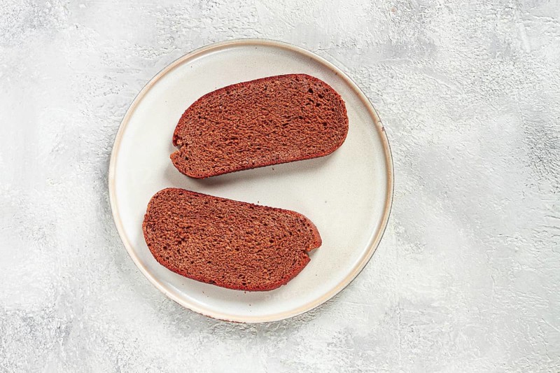 Delicious slices of homemade dark bread on a simple ceramic plate in a kitchen setting