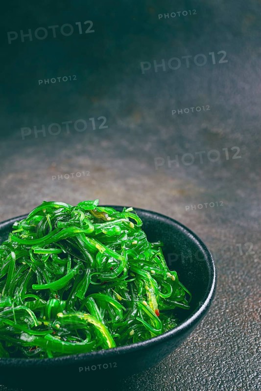Chuka salad, made from fresh seaweed, with sesame dressing, served in a black bowl