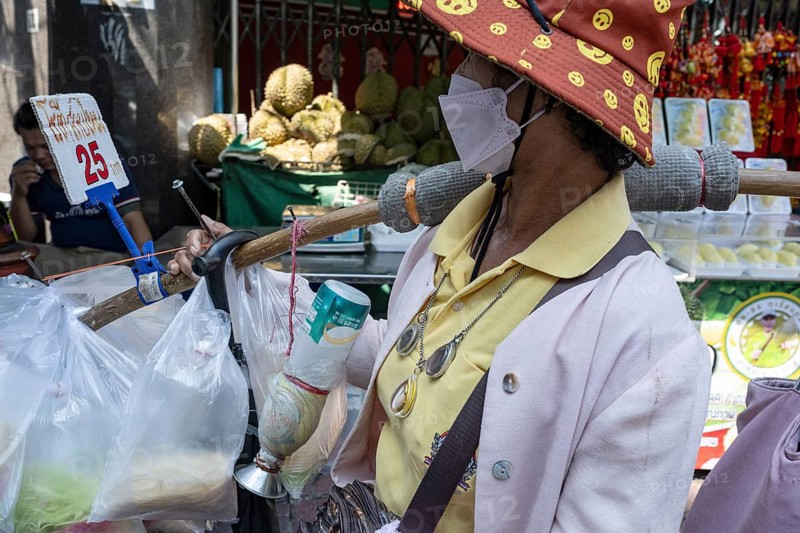 Bangkok, Thailand. March 25th 2025. A local women selling street food wearing a face mask to protect against infections and poor air quality in Bangkok, a heavily polluted mega city, Thailand, Asia