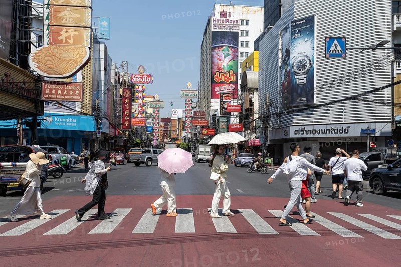 Bangkok, Thailand. March 25th 2025. Tourists crossing Yaowarat Road, the heart of Chinatown and popular destination for street food and entertainment in Bangkok, Thailand