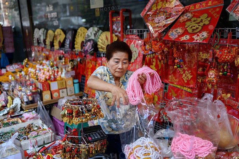 Bangkok, Thailand. February 18th 2025. A woman selling Chinese souvenirs and gifts from a street side stall along Yaowarat Road, Chinatown, Bangkok, Thailand