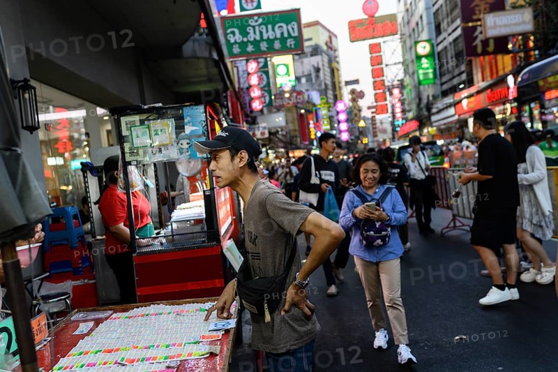 Bangkok, Thailand. February 18th 2025. A local man stops to buy lottery tickets along a busy Yaowarat Road, Chinatown, Bangkok, Thailand