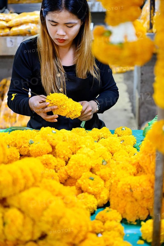 Bangkok, Thailand. March 4th 2025. A Thai woman making traditional flower garlands at Pak khlong Talat, a Bangkok flower market
