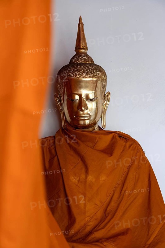 A golden Buddha image covered in orange cloth in preparation for cleaning at Wat Pho Temple complex known for The Reclining Buddha, Bangkok, Thailand