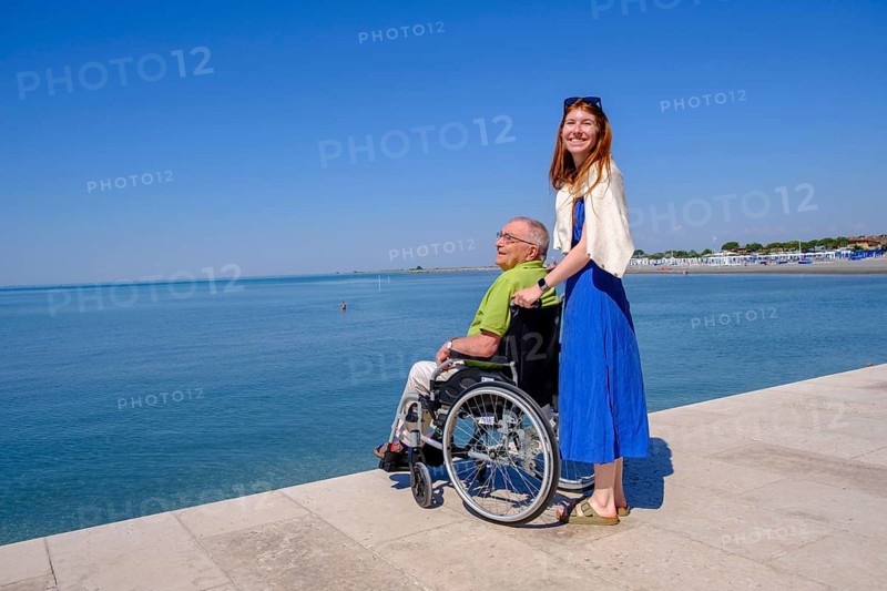 Senior in wheelchair looking at the sea, vacation with a handicap, Grado, Julian-Friuli, Adriatic Sea, Italy