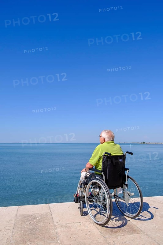 Senior in wheelchair looking at the sea, vacation with a handicap, Grado, Julian-Friuli, Adriatic Sea, Italy